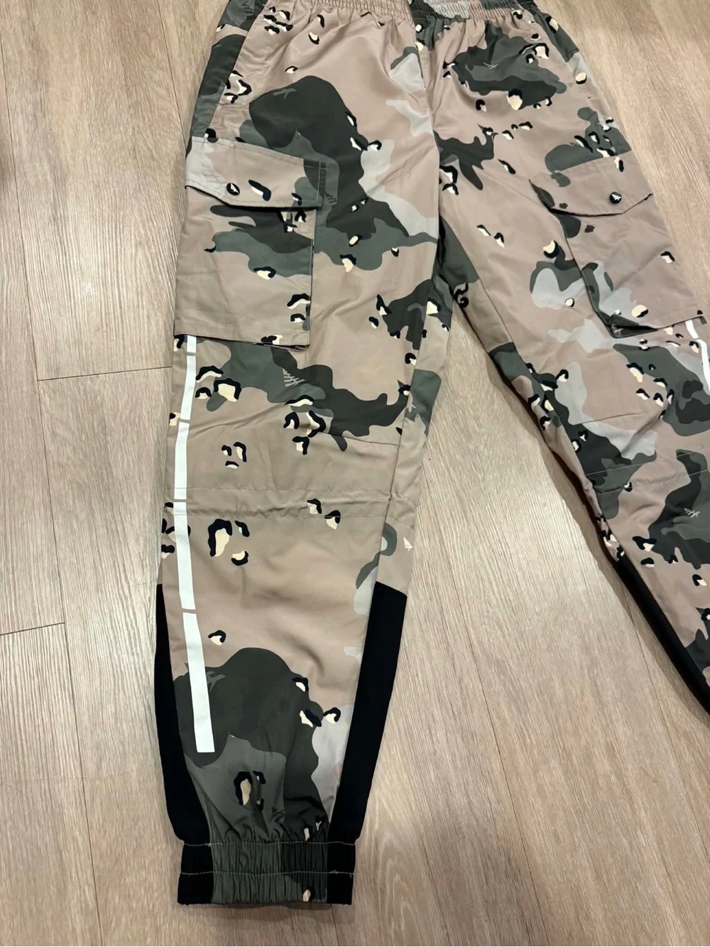 Paper Planes multi-pocket cargo pants featuring an all-over camouflage print